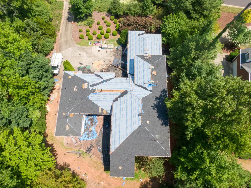 Aerial view of a residential roof undergoing commercial roofing repairs in Acton, California.