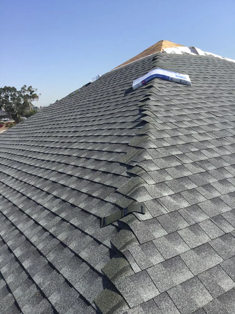 New roof shingles being installed on a residential home in Los Angeles County, California, with workers securing fresh roofing materials during a roof replacement project