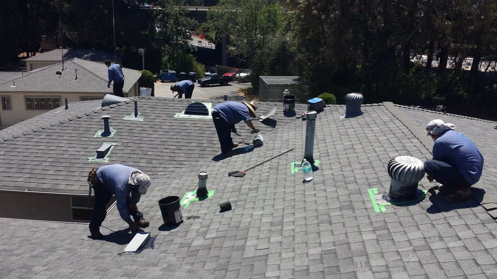 Rooftop maintenance crew works on a commercial building roof in Los Angeles County, California, checking materials, equipment, and overall roof condition