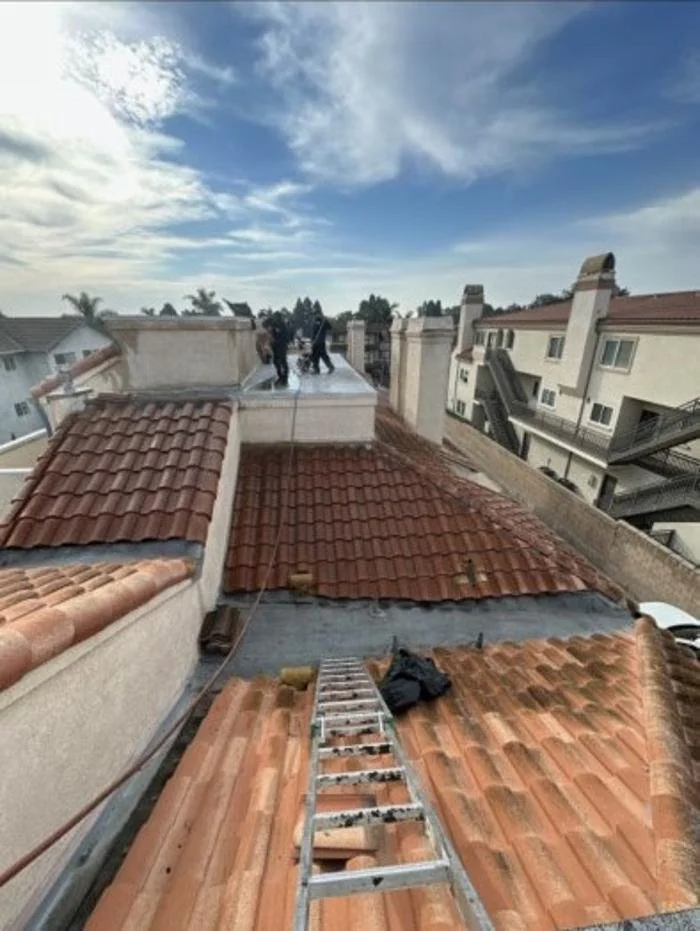 Roofing crew performing rooftop work in progress on a residential property in Los Angeles County, California