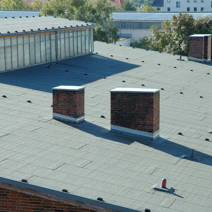 Flat roof with twin brick chimneys on an Orange County, California home, showing clean masonry lines and a low-profile roof design