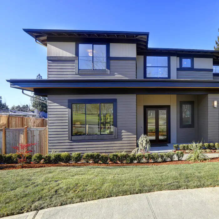 Modern two-story house front in Orange County, California, with clean lines, large windows, a sleek entry, and manicured landscaping