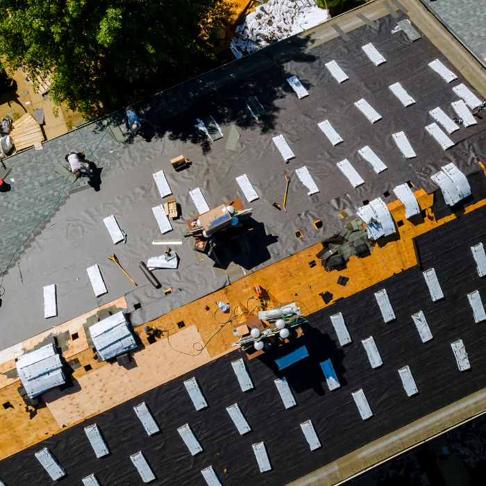 Rooftop construction project in Orange County, California, showing workers, framing, and active residential roof installation