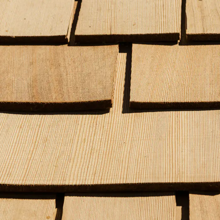 Textured wooden roof shingles in warm brown tones covering a residential roof in Orange County, California with visible natural detail